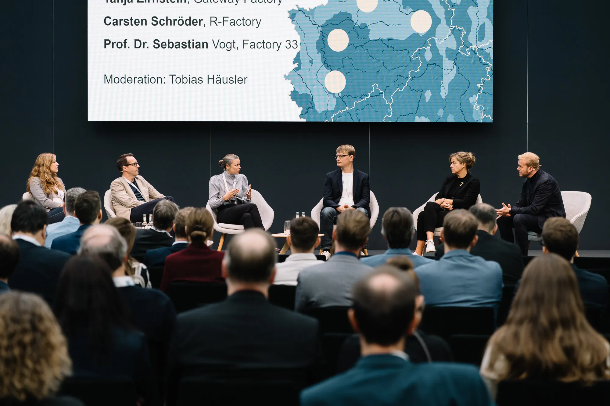 Talkrunde mit mehreren Personen, darunter Mona Neubaur, Publikum im Vordergrund